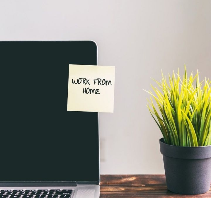 Homeoffice mit Laptop, Pflanze und Post-it